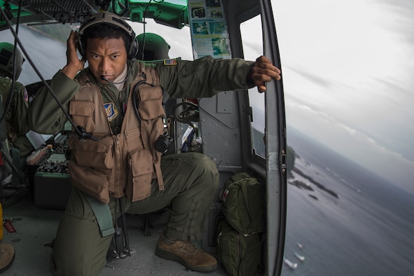 Maj. Zensaku Munn listens to the radio Aug. 31, 2014, during the Shizuoka Comprehensive Disaster Drill over Shimoda bay, Japan. Munn relayed drop clearance to the inbound C-130 Hercules from a UH-1N Iroquois during the drill. Munn is a 374th Operations Support Squadron air mobility liaison officer. (U.S. Air Force photo/Osakabe Yasuo) 