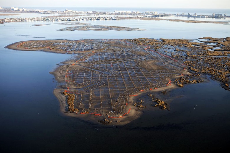 An aerial view of three Jamaica Bay Marsh Islands in Queens and Brooklyn, New York, restored in 2012 by the U.S. Army Corps of Engineers, New York District and regional partners by placing clean sand over roughly 75 acres of marsh land. Above, facing east, islands Yellow Bar Hassock (foreground), Black Wall (directly behind it), and Rulers Bar (directly behind Black Wall) with Cross Bay Boulevard in background. The effort is part of a larger initiative restoring the Hudson-Raritan Estuary. To that end, a symposium, “Restoring the New York-New Jersey Harbor Estuary: Ensuring Ecosystem Resilience and Sustainability in a Changing Future,” held June 3, 2014 in Manhattan, attracted more than 200 scientists, engineers, academics and restoration professionals discussing progress and new initiatives to restore the Estuary. 