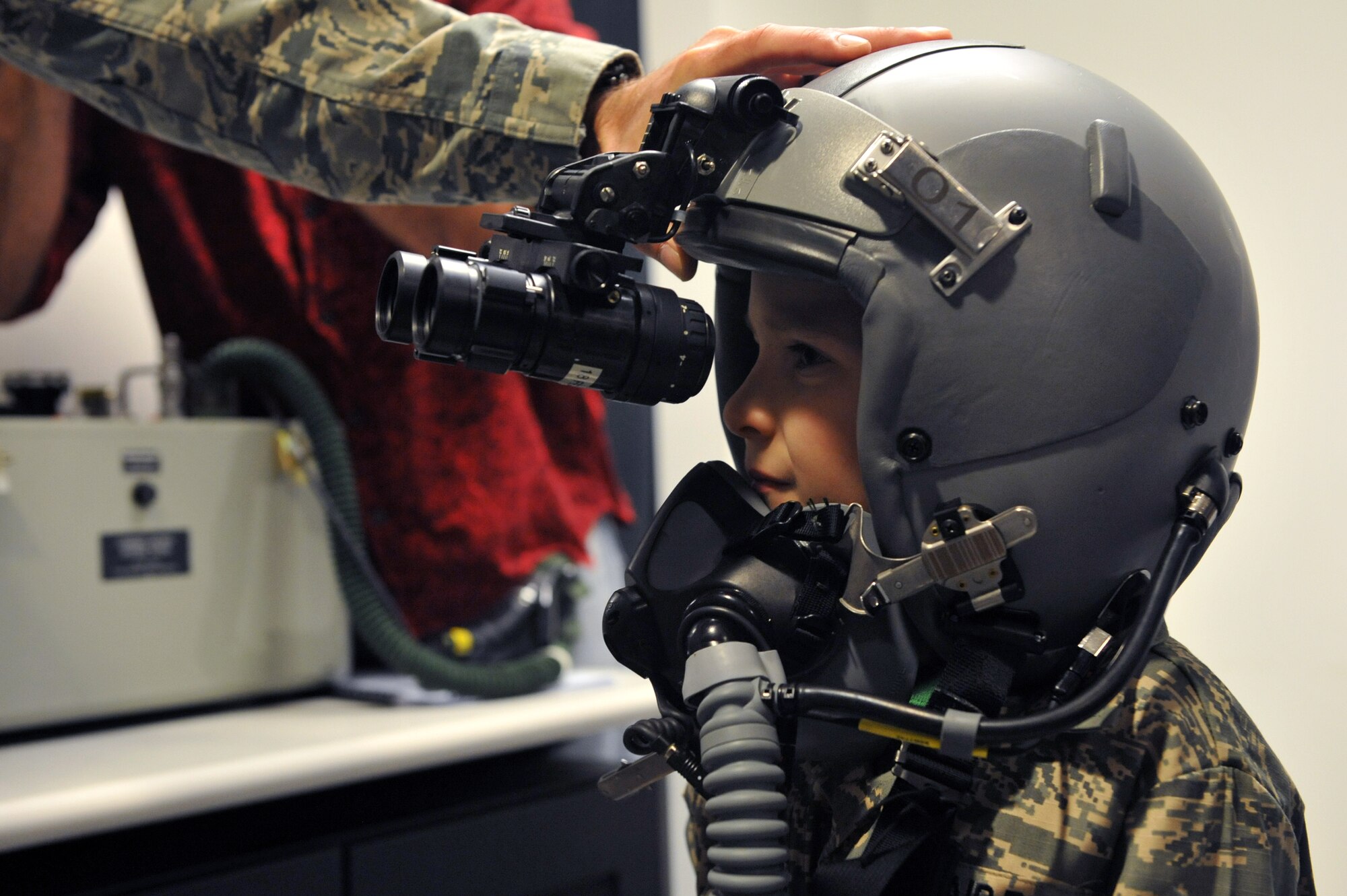 Keegan Stipe, left, a 7-year-old boy who is overcoming transverse myelitis, a spinal condition that limits his ability to walk, tries on pilot gear during his Airman for a Day base tour Aug. 26, 2014, on Buckley Air Force Base, Colo. Keegan has always been fascinated with fast planes, loud guns and the military lifestyle, so the 460th Space Wing gave him and his parents the opportunity to visit the base. On his tour, he visited the 140th Wing, Air National Guard and various 460th SFS sections. (U.S. Air Force photo by Airman Emily E. Amyotte/Released)