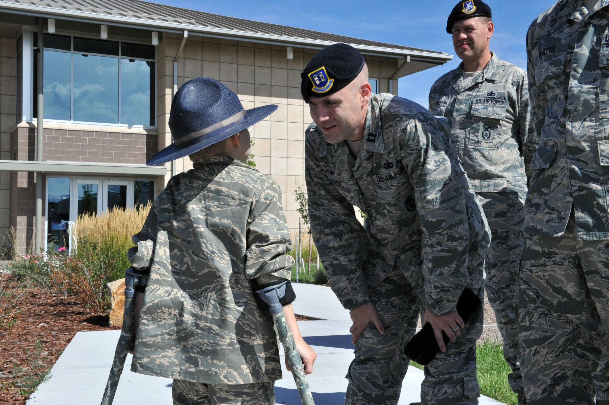 Keegan Stipe, left, a 7-year-old boy who is overcoming transverse myelitis, a spinal condition that limits his ability to walk, is greeted by Capt. Jason Stack, 460th Security Forces Squadron commander, second from left, and other security forces members during his Airman for a Day base tour Aug. 26, 2014, on Buckley Air Force Base, Colo. Keegan has always been fascinated with fast planes, loud guns and the military lifestyle, so the 460th Space Wing gave him and his parents the opportunity to visit the base. On his tour, he visited the 140th Wing, Air National Guard and various 460th SFS sections. (U.S. Air Force photo by Airman Emily E. Amyotte/Released)