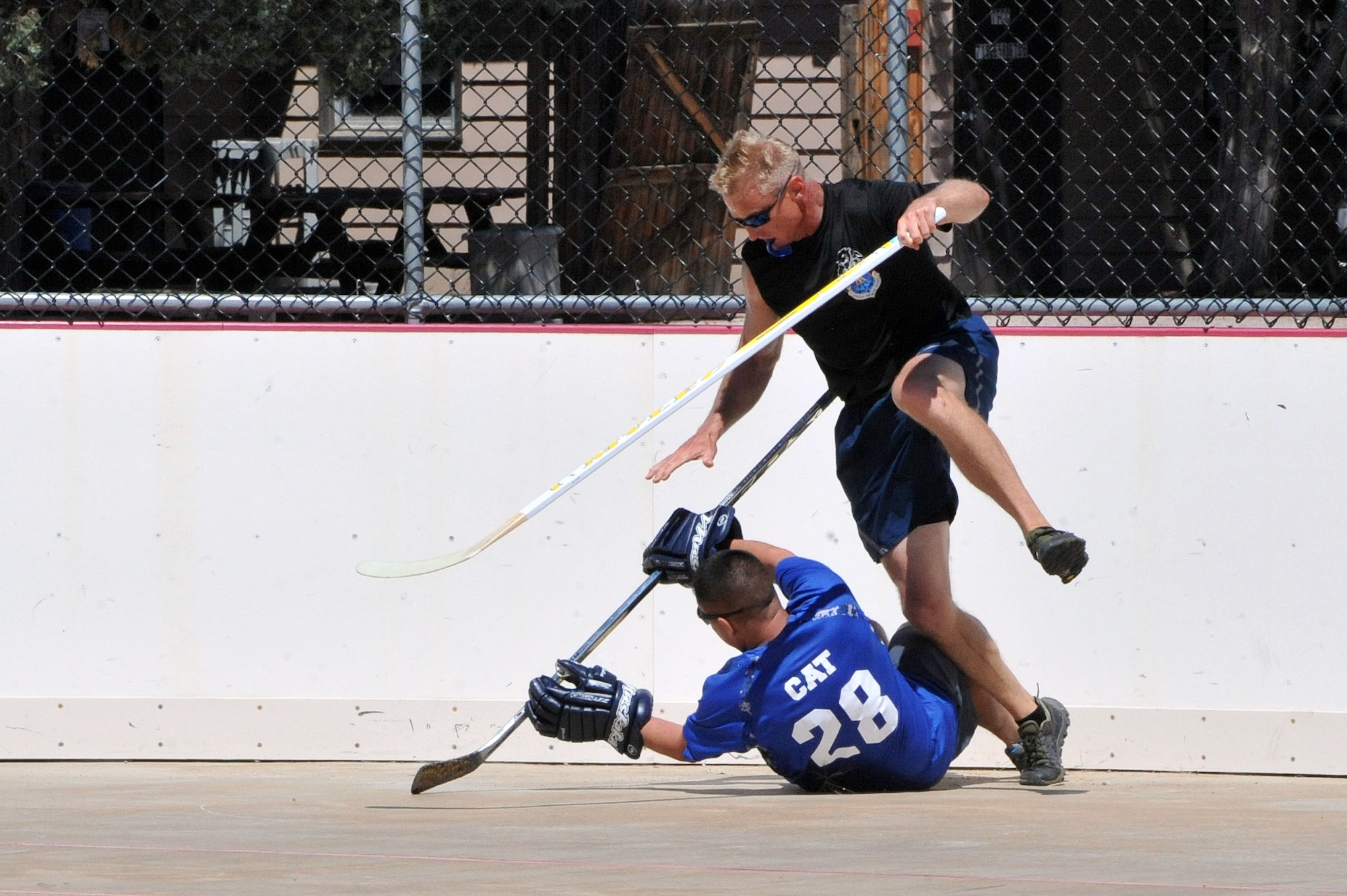Chief Master Sgt. Craig S. Hall, 460th Space Wing command chief, gets competitive as he plays defense during a ball hockey game at the Tri-Wing Sports Challenge Aug. 27, 2014, at Peterson Air Force Base, Colo. More than 100 Team Buckley members traveled to Peterson Air Force Base to compete and support the Panthers during the games. (U.S. Air Force photo by Airman Emily E. Amyotte/Released)