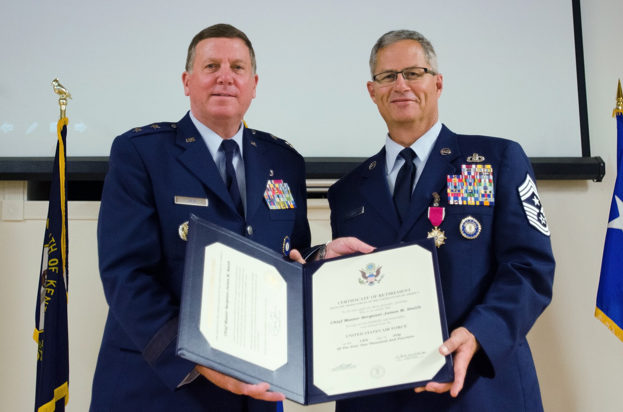 Maj. Gen. Edward W. Tonini (left), Kentucky’s adjutant general, presents Chief Master Sgt. James Smith, the Kentucky National Guard’s outgoing state command chief, with Smith’s retirement certificate during a ceremony at the Kentucky Air National Guard Base in Louisville, Ky., on July 12, 2014. Smith served in the Air National Guard for more than 36 years. (U.S. Air National Guard photo by Senior Airman Joshua Horton)