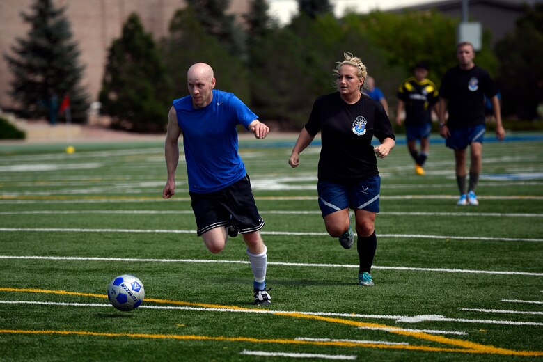 Collin Merrin, 3rd Space Operations Squadron, dribbles past a defender during the soccer game of the first annual Tri-Wing Sports Challenge Aug. 27, at Peterson Air Force Base, Colo. Team Schriever placed second overall in the competition. (U.S. Air Force Photo/Christopher DeWitt)