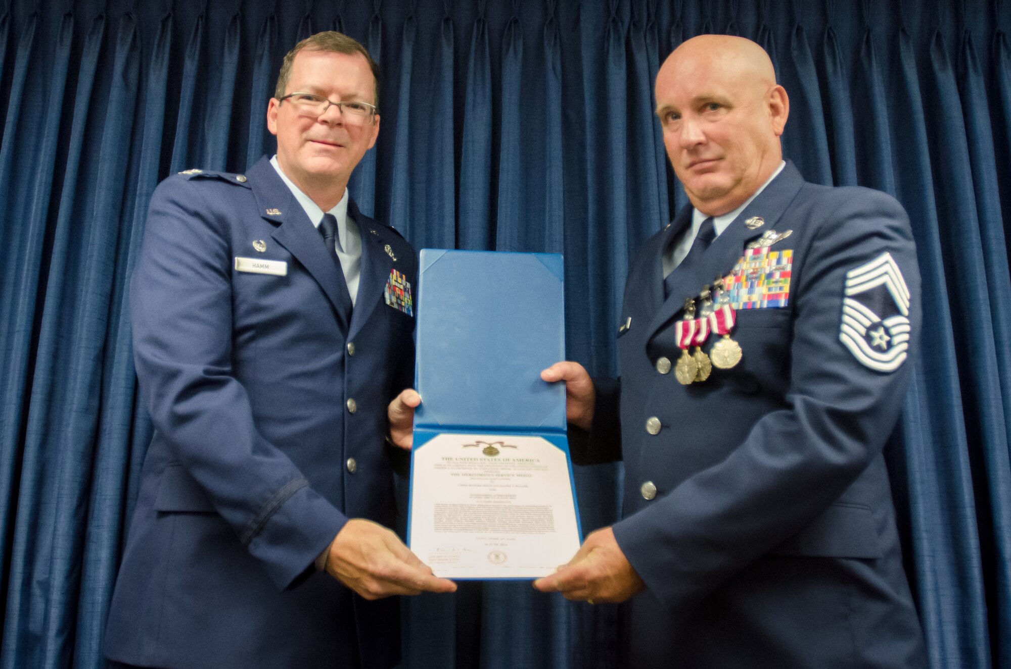 Chief Master Sgt. Daniel Fuller (right), the outgoing superintendent of the Kentucky Air National Guard’s 123rd Operations Group, is awarded the Meritorious Service Medal by Col. Robert Hamm, commander of the Operations Group, during Fuller’s retirement ceremony at the Kentucky Air National Guard Base in Louisville, Ky., June 8, 2014.  Fuller retired after 36 years of service. (U.S. Air National Guard photo by Senior Airman Joshua Horton)