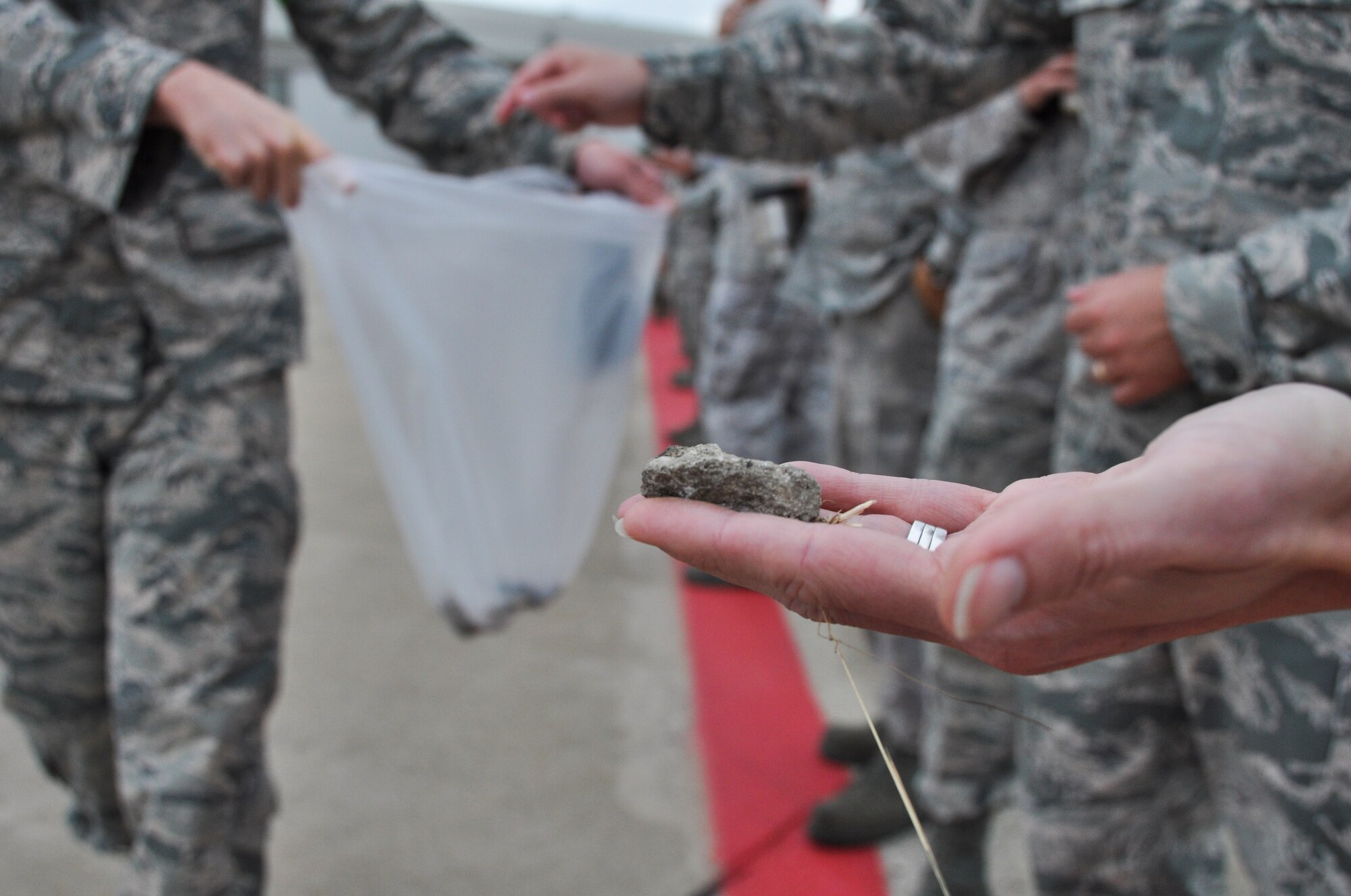 911th Airlift Wing Airmen and personnel participate in a Foreign Objects Debris (FOD) walk early morning, Aug. 11, 2014. Every week personnel line up and walk the flight line to collect any objects, such as rocks, plastic, or rubber, that could create damage to planes or vehicles. (U.S. Air Force photo by Senior Airman Justyne Obeldobel)