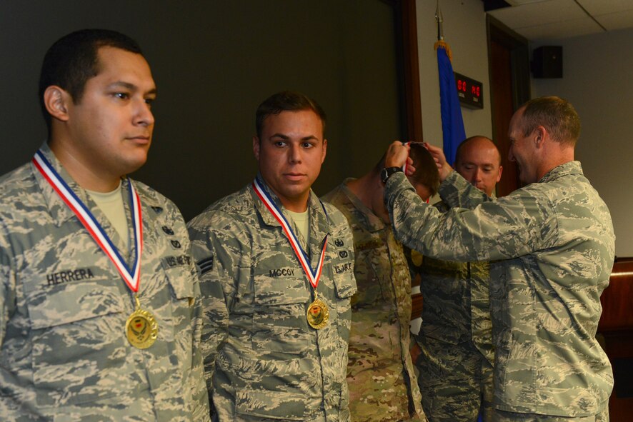 Airmen assigned to the 20th Civil Engineer Squadron receive medals from Col. Stephen Jost, 20th Fighter Wing commander, for winning the 20th Force Support Squadron Amazing Race at Shaw Air Force Base, S.C., Sept. 3, 2014. Participants ran across the base to specified locations and completed challenges presented at each location before the other teams to win. (U.S. Air Force photo by Airman 1st Class Diana M. Cossaboom/Released)