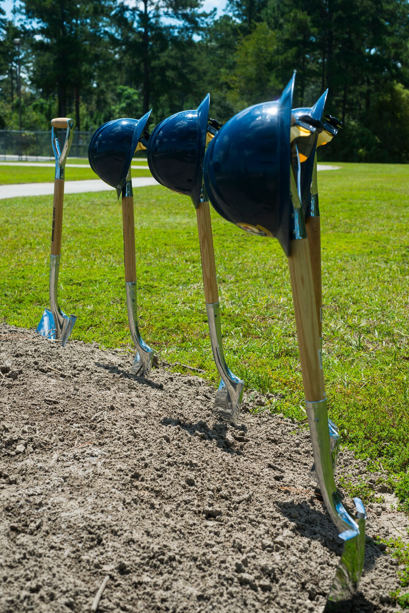 Hard hats and shovels rest in the dirt during a military service station groundbreaking ceremony at Moody Air Force Base, Ga., Sept. 3, 2014. The service station will offer four grades of ground fuel including E-85 and the 23d LRS currently drives off base to refuel 38 vehicles because the current service station cannot offer E-85 fuel. (U.S. Air Force photo by Airman 1st Class Ceaira Tinsley/Released)