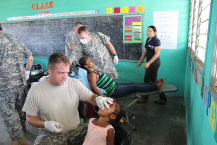 U.S. Army Sgt. 1st Class Noah Cunningham (front) and Spec. Brandon Tigges provide dental care during a medical readiness training exercise Aug. 25-28 in the remote village of Rio Platano, Department of Gracias a Dios, Honduras.  MEDEL partnered with the Honduran Ministry of Health and the Honduran military to provide classes for the patients to teach them about hygiene, nutrition, and preventative dental practices.  They also provide wellness checkups, medication, dental care, and perform minor medical procedures as required.  (Photo by U.S. Army Spec. Anthony Gonzales)