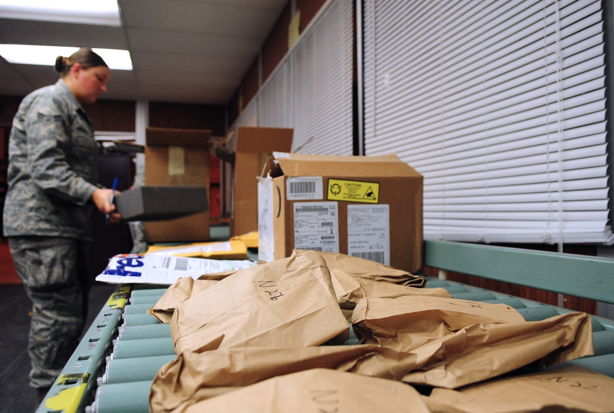U.S. Air Force Airman 1st Class Abby Heckman, a 354th Logistics Readiness Squadron inbound receiving process specialist, unloads packages during an integrated receipt process Aug. 20, 2014, Eielson Air Force Base, Alaska. Every package that arrives in the IRP must be examined and processed before delivery to the customer. (U.S. Air Force photo by Senior Airman Lauren-Taylor Levin/Released)