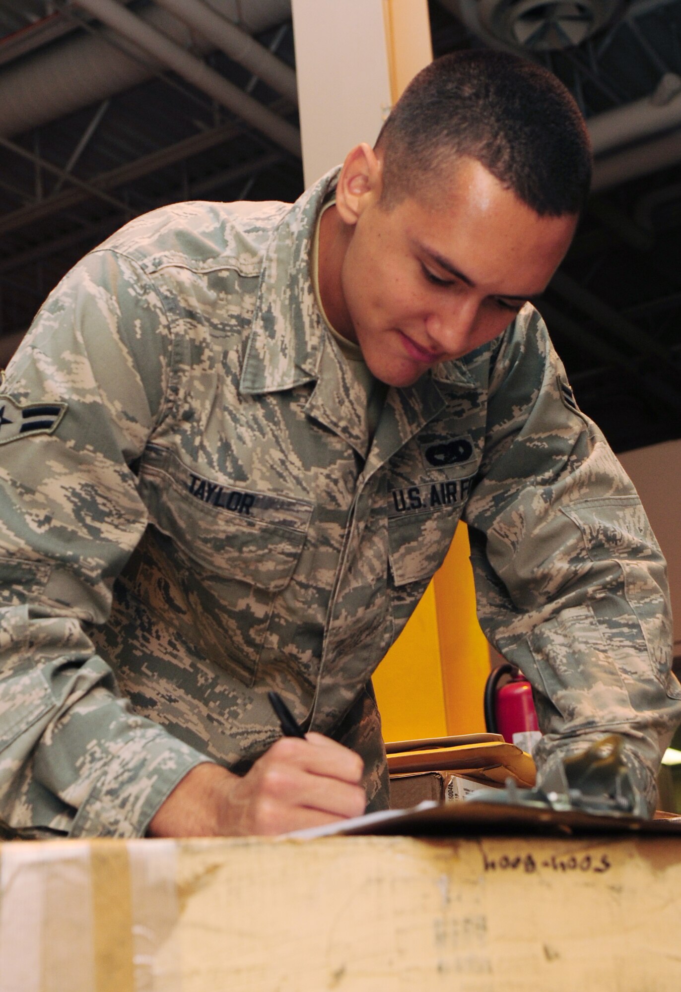 U.S. Air Force Airman 1st Class Nicholas Taylor, a 354th Logistics Readiness Squadron transportation specialist, checks incoming packages during an integrated receipt process Aug. 20, 2014, Eielson Air Force Base, Alaska. Taylor writes down the date of all incoming packages before items are distributed across Eielson. (U.S. Air Force photo by Senior Airman Lauren-Taylor Levin/Released)
