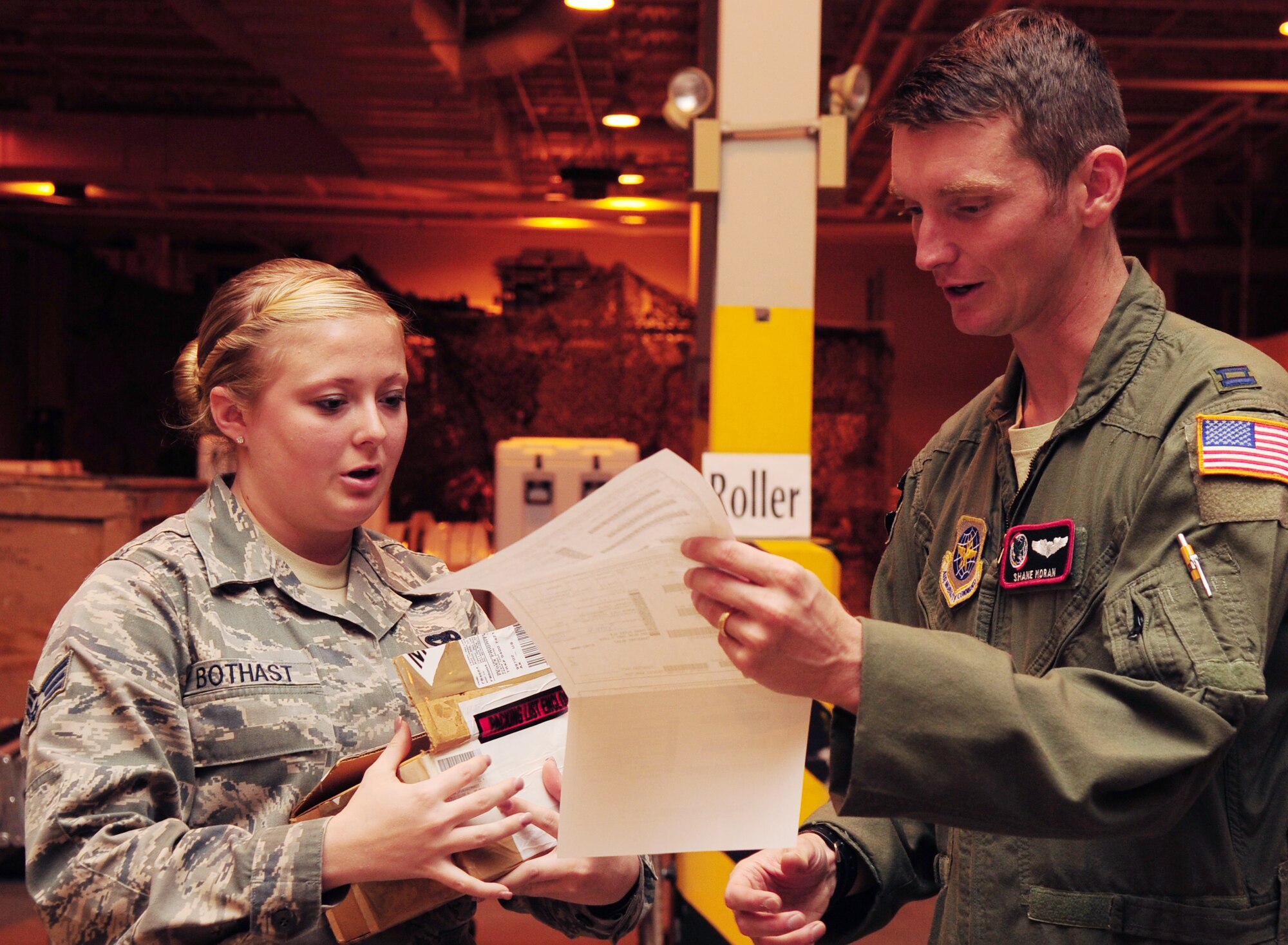 U.S. Air Force Capt. Shane Moran, 92nd Air Refueling Wing pilot, receives an aircraft part from Senior Airman Breyana Bothast, a 354th Logistics Readiness Squadron inbound receiving process specialist, during an integrated receipt process Aug. 20, 2014, Eielson Air Force Base, Alaska. Moran was a participant in RED FLAG-Alaska 14-3. (U.S. Air Force photo by Senior Airman Lauren-Taylor Levin/Released)