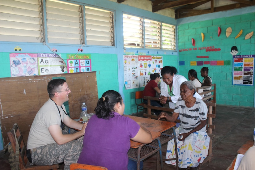 A Honduran woman tells U.S. Army Sgt. Patrick Oaks her symptoms during a medical readiness training exercise Aug. 25-28 in the remote village of Rio Platano, Department of Gracias a Dios, Honduras.  MEDEL partnered with the Honduran Ministry of Health and the Honduran military to provide classes for the patients to teach them about hygiene, nutrition, and preventative dental practices.  They also provide wellness checkups, medication, dental care, and perform minor medical procedures as required.  (Photo by U.S. Army Spec. Anthony Gonzales)