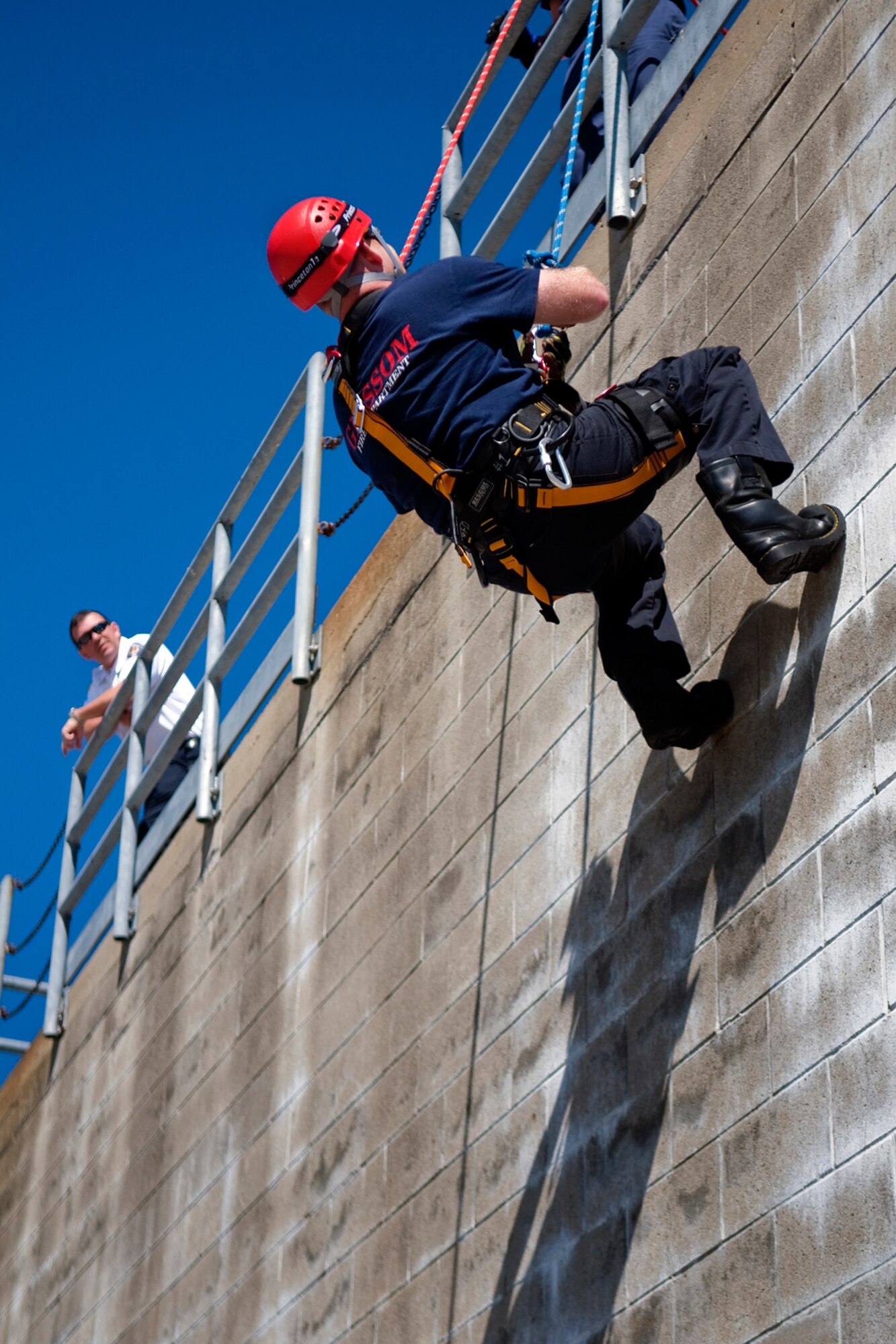 Timothy McMahon, Grissom Fire Department assitant chief, watches as Jamie Lay, GFD firefighter, rappels down a fire training tower at Grissom Air Reserve Base, Ind., Aug. 15, 2014. More than a dozen of the GFD's 49 firefighters are certified rescue trained, allowing them to conduct rescues from high angles, low angles, in confined spaces and from under collapsed structures. (U.S. Air Force photo/Tech. Sgt. Mark R. W. Orders-Woempner) 
