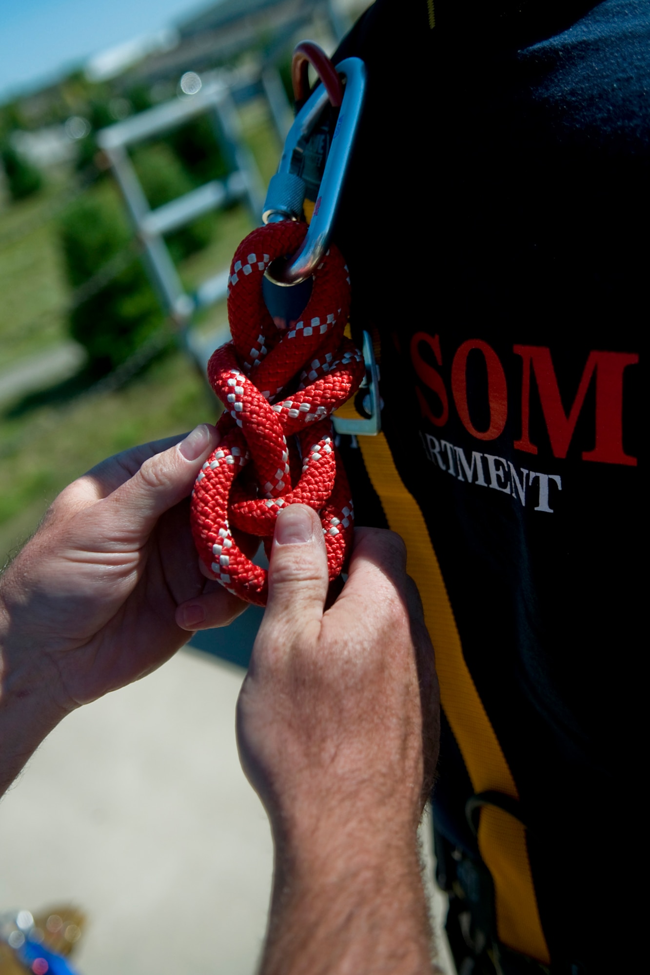 Robert Jacobs, Grissom Fire Department firefighter, ties a knot to secure a rope on Jamie Lay, GFD firefighter, prior to Lay rappelling down a fire training tower at Grissom Air Reserve Base, Ind., Aug. 15, 2014. More than a dozen of the GFD's 49 firefighters are certified rescue trained, allowing them to conduct rescues from high angles, low angles, in confined spaces and from under collapsed structures. (U.S. Air Force photo/Tech. Sgt. Mark R. W. Orders-Woempner) 
