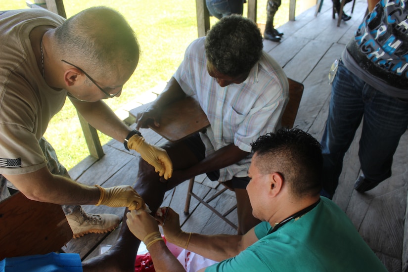A JTF-Bravo Medical Element (MEDEL) and Honduran medic treat a Honduran man's leg during a medical readiness training exercise Aug. 25-28 in the remote village of Rio Platano, Department of Gracias a Dios, Honduras.  MEDEL partnered with the Honduran Ministry of Health and the Honduran military to provide classes for the patients to teach them about hygiene, nutrition, and preventative dental practices.  They also provide wellness checkups, medication, dental care, and perform minor medical procedures as required.  (Photo by U.S. Army Spec. Anthony Gonzales)