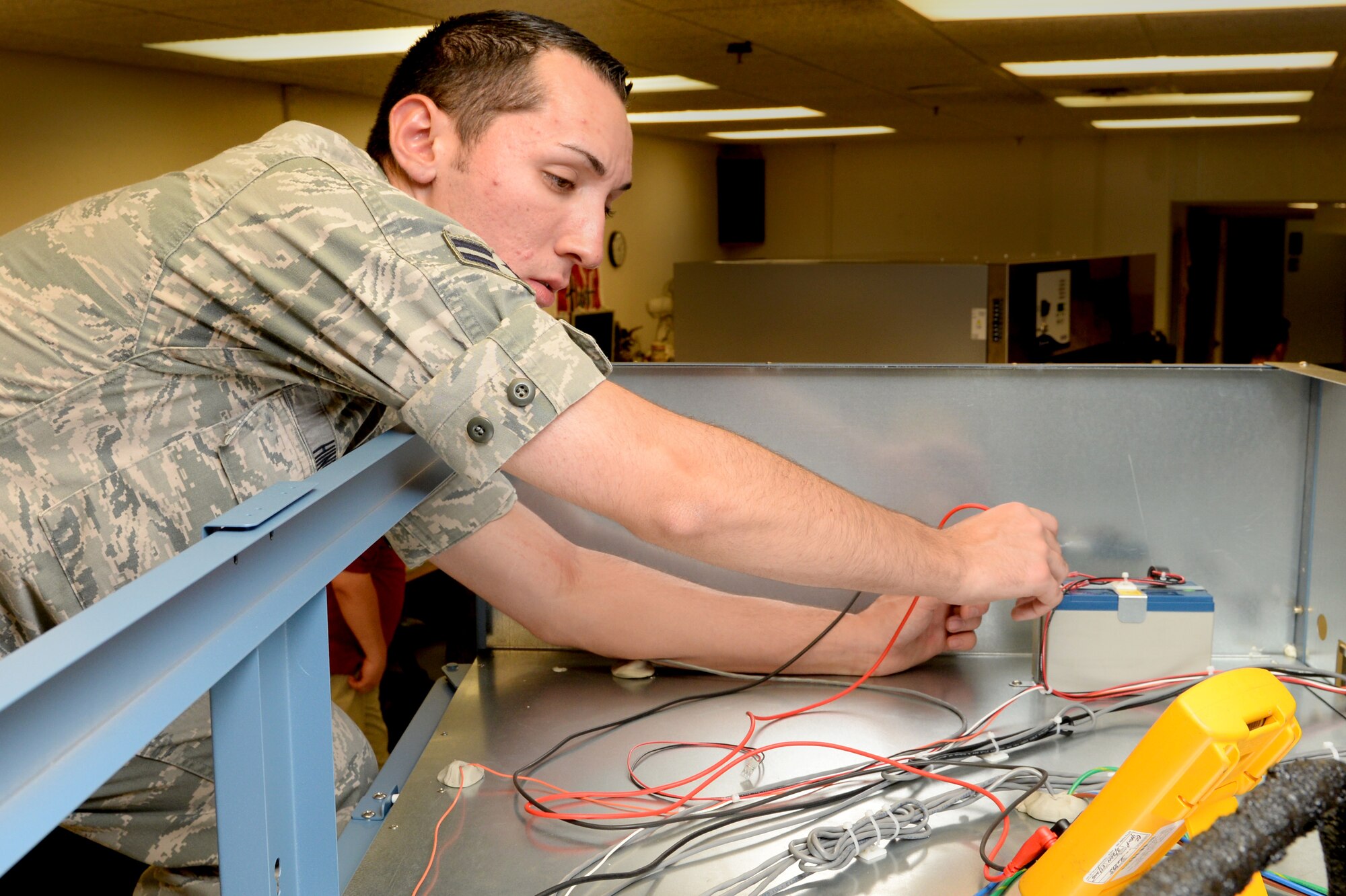 Airman 1st Class Russell Hinds test electrical wires on a lab refrigerator August 28, 2014 at Scott Air Force Base, Ill. Hinds is a technician who assist with repairing equipment from 13 states. Hinds is a member of the 375th Medical Support Squadron Medical Equipment Repair Center. (U.S. Air Force photo/ Airman 1st Class Kiana Brothers)
