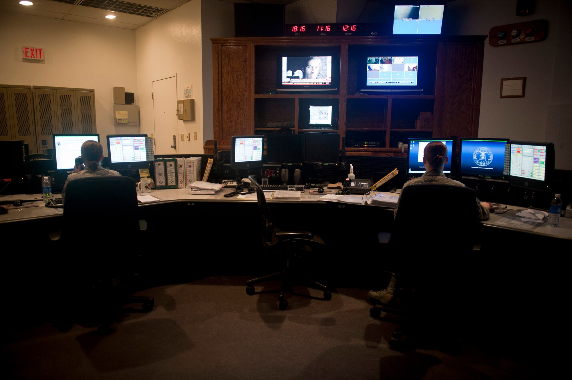 Tech. Sgt. Laura Langley (left) and Senior Airman Sarah Myers, 99th Air Base Wing Command Post senior and junior controllers, field phone calls at their workstations at Nellis Air Force Base, Nev., Aug. 21, 2014. Command post controllers are the ‘eyes and ears’ of Nellis and Creech AFBs, and constantly monitor interactions occurring on both installations. (U.S. Air Force photo by Staff Sgt. Siuta B. Ika)