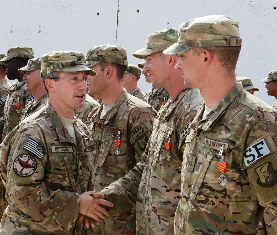 NATO Air Training Command-Afghanistan and 438th Air Expeditionary Wing commander, Brig. Gen. Michael Rothstein, congratulates Staff Sergeants John DeYoung and Mikal Hanson after they and 37 other members of the 439th Air Expeditionary Advisory Squadron security forces were awarded the Air Force Combat Action Medal in a ceremony at Forward Operating Base Oqab, Afghanistan, Sept. 2, 2014. The Air Force recognized the Airmen for their service during a more than five-hour firefight against Taliban-linked insurgents attacking the base and adjacent bases July 17, 2014. (U.S. Air Force photo/Senior Master Sgt. Mike Hammond)