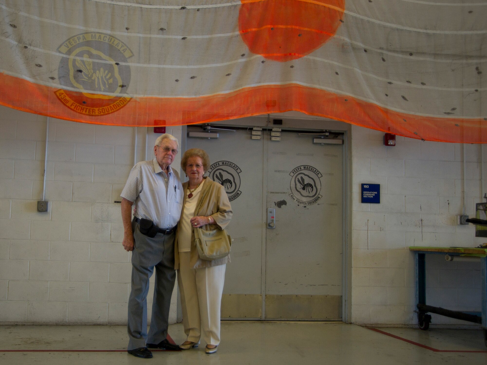 Ed and Mary Butzke stand for a picture in front of a tow banner Aug 25. The Butzkes toured Tyndall after being gone for more than 70 years. (U.S. Air Force photo by Airman 1st Class Dustin Mullen)