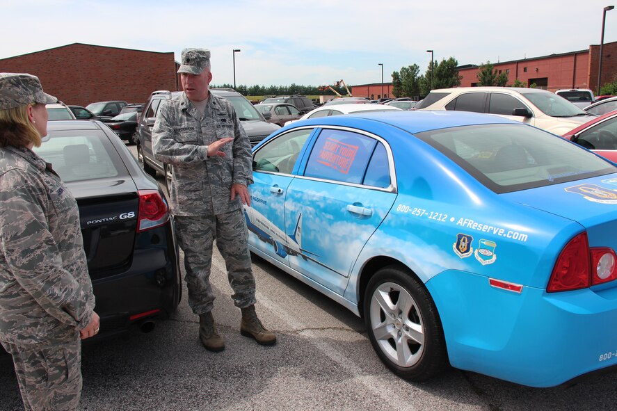 Col. Constance Jenkins and Lt. Col. Roger Stoeckmann from the 932nd Mission Support Group discuss the new "paint" scheme of the recruiting vehicle in the parking lot of the headquarters building.  This car features a wrap of the unit's flying aircraft, the C-40C, and the toll free number of 1-800-257-1212 for those who might be interested in joining the Air Force Reserve Command wing at Scott Air Force Base, Ill.  (U.S. Air Force photo/Maj. Stan Paregien)