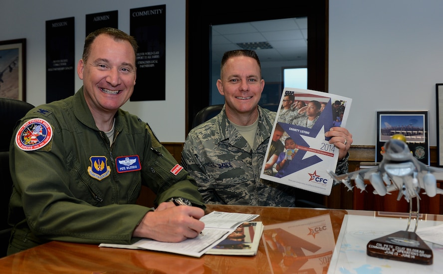 U.S. Air Force Col. Pete M. Bilodeau, 52nd Fighter Wing commander, left, and U.S. Air Force Chief Master Sgt. Brian J. Gates, 52nd FW command chief, make donations through the Combined Federal Campaign-Overseas at Spangdahlem Air Base, Germany, Sep. 3, 2014.  The CFC-O is a charity fundraiser that allows people to donate money to more than 2,500 organizations to help those in need. (U.S. Air Force photo by Airman 1st Class Luke J. Kitterman/Released)
