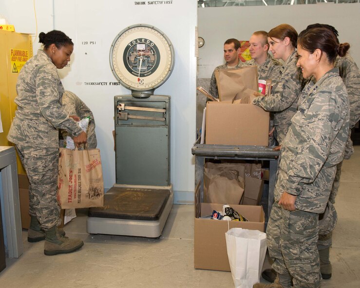 Feds Feed Families volunteers, Capt. Letricia Castillo (left) and others weigh non-perishable food donations on base that were contributed to the Feds Feed Families food drive Aug. 27. Organizers have extended this year’s food drive through Sept. 12. The drive, which officially began June 1, is collecting non-perishable food items that will be donated to the Greater Boston Food Bank. (U.S. Air Force photo by Mark Herlihy) 
