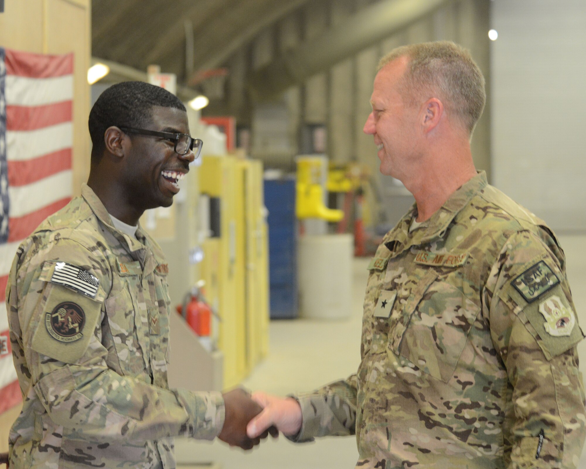 U.S. Air Force Airman First Class Nana Sefa (left), 455th Expeditionary Logistics Readiness Squadron vehicle management analysis craftsman, shakes hands with Brig. Gen. Mark Kelly, 455th Air Expeditionary Wing commander, during an immersion tour at Bagram Airfield, Afghanistan July 29, 2014. Sefa, a Ghana native, is currently deployed from Holloman Air Force Base, New Mexico.  (U.S. Air Force photo by Master Sgt. Cohen Young/Released)