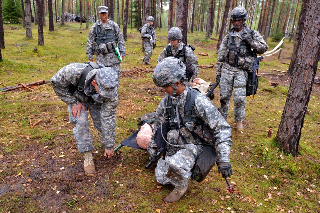 U.S. Army 2nd Lt. Allison Erickson, right, and three other soldiers practice the four-man litter carry during the U.S. Army Europe Expert Field Medical Badge competition on the Joint Multinational Training Command's Grafenwoehr Training Area, Germany, Aug. 26, 2014. Erickson is assigned to the Bavaria Medical Department Activity.