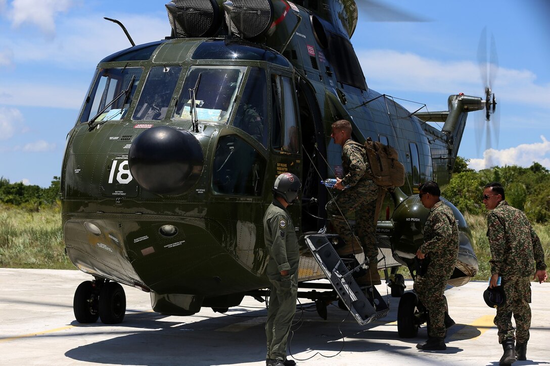 Col. Matthew G. Trollinger, center, commanding officer, 11th Marine Expeditionary Unit, boards a Sikorsky SH-3 Sea King following the closing ceremony of Malaysia-United States Amphibious Exercise 2014 at Kg Tanduo Beach, Malaysia, Sept. 2. MALUS AMPHEX 14 is a bilateral exercise between the 11th MEU and Malaysian Armed Forces that includes operational and tactical level training in planning, command and control, and combat service support using both ground and sea assets. (U.S. Marine Corps photo by Gunnery Sgt. Rome M. Lazarus/Released)