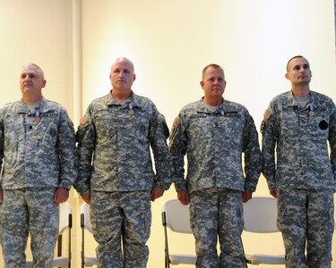 Army Lt. Col. Hunter L. Belcher, Army Maj. William J. Crawford, Command Sgt. Maj. Christopher T. Crawford and Sgt. 1st Class Fred C. Mize III stand on stage after receiving the Soldier’s Medal for actions they took during life threatening, emergency situations. The Soldier’s Medal is the Army’s highest award for heroism in a non-combat environment.