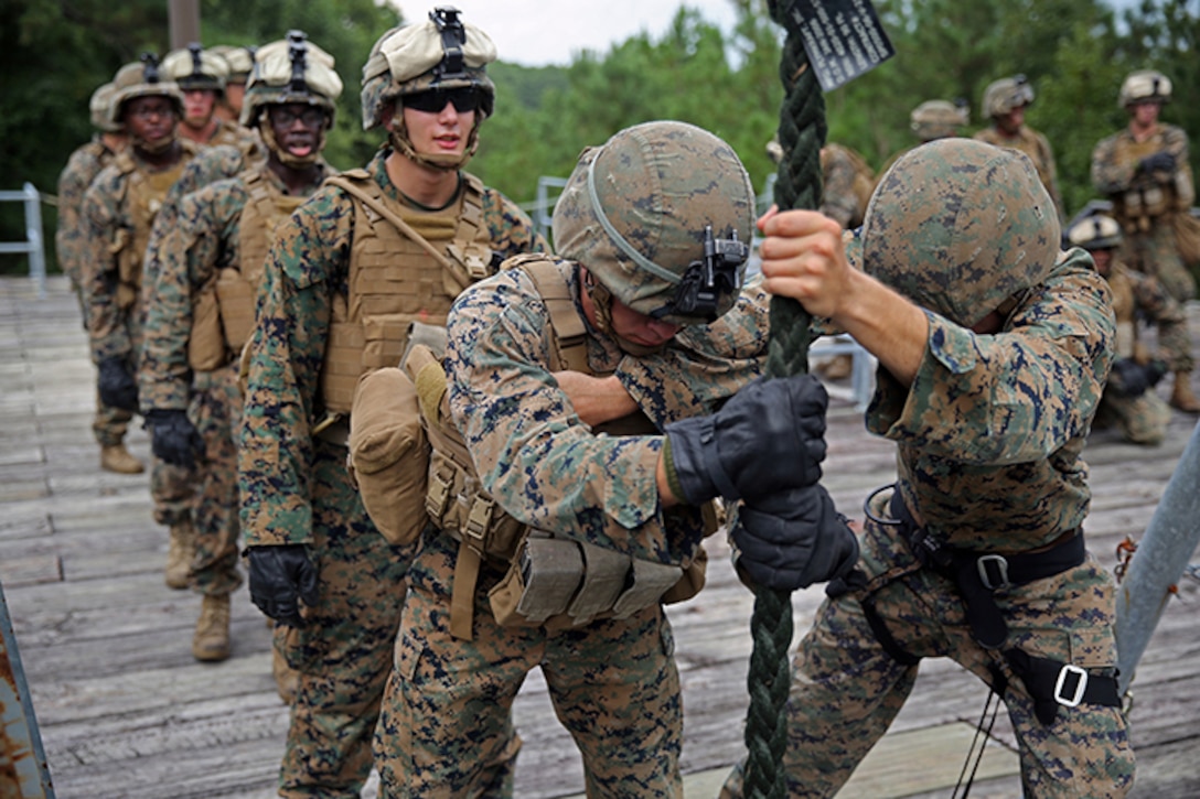 A Helicopter Rope Suspension Training, or HRST, Master, right, with Battalion Landing Team 3rd Battalion, 6th Marine Regiment, 24th Marine Expeditionary Unit, gives instructions to a Marine before descending a rope during Fast-Rope Insertion Extraction System qualification at Camp Lejeune, N.C., August 21, 2014. Marines spent two days fast-roping from a tower and an MV-22B Osprey in preparation for their scheduled deployment at the end of the year. (U.S. Marine Corps photo by Sgt. Devin Nichols)