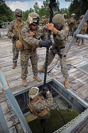 A Helicopter Rope Suspension Training, or HRST, Master, right, with Battalion Landing Team 3rd Battalion, 6th Marine Regiment, 24th Marine Expeditionary Unit, gives instructions to a Marine before descending a rope during Fast-Rope Insertion Extraction System qualification at Camp Lejeune, N.C., August 21, 2014. Marines spent two days fast-roping from a tower and an MV-22B Osprey in preparation for their scheduled deployment at the end of the year. (U.S. Marine Corps photo by Sgt. Devin Nichols)