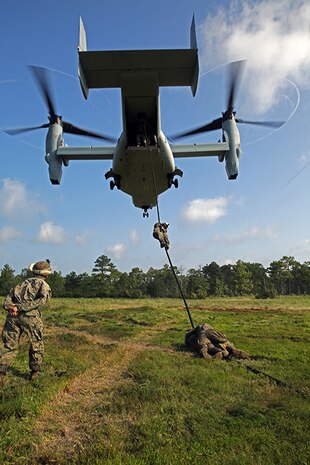 An MV-22B Osprey from Marine Medium Tiltrotor Squadron 365 (Reinforced), 24th Marine Expeditionary Unit, hovers as a Marine with Battalion Landing Team 3rd Battalion, 6th Marine Regiment, 24th MEU, descends a rope during Fast Rope Insertion Extraction System qualification at Camp Lejeune, N.C., August 22, 2014. Marines spent two days fast-roping from a tower and an MV-22B Osprey in preparation for their scheduled deployment at the end of the year. (U.S. Marine Corps photo by Sgt. Devin Nichols)