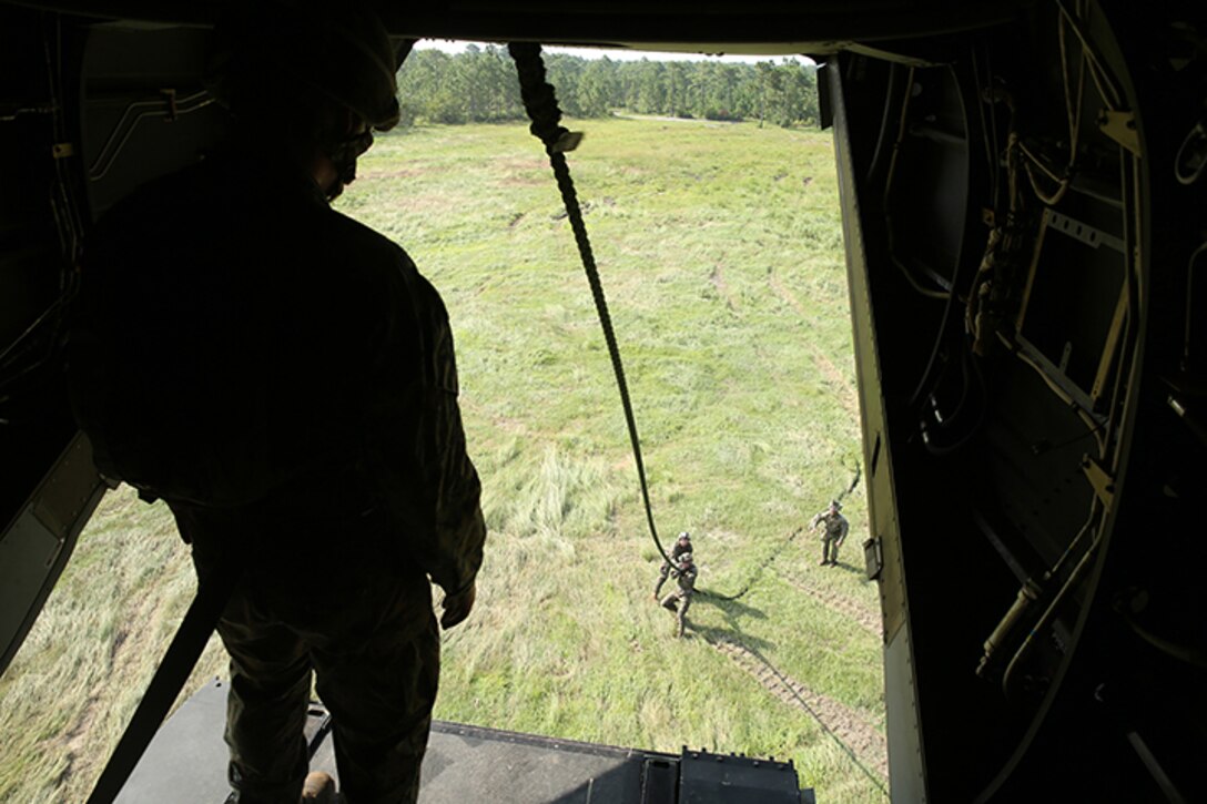 A Marine with Battalion Landing Team 3rd Battalion, 6th Marine Regiment, 24th Marine Expeditionary Unit, descends a rope from an MV-22B Osprey from Marine Medium Tiltrotor Squadron 365 (Reinforced), 24th MEU, during Fast Rope Insertion Extraction System qualification at Camp Lejeune, N.C., August 22, 2014. Marines spent two days fast-roping from a tower and an MV-22B Osprey in preparation for their scheduled deployment at the end of the year. (U.S. Marine Corps photo by Sgt. Devin Nichols)