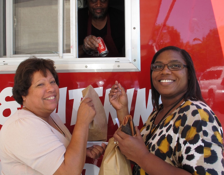 Huntsville Center employees, Becky Sandoval and Andora Dothard, purchase food items from truck July 28.                   