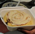 A local merchant holds up cinnamon roll treat before making sale at Team Spirit  lunch event August 28. 