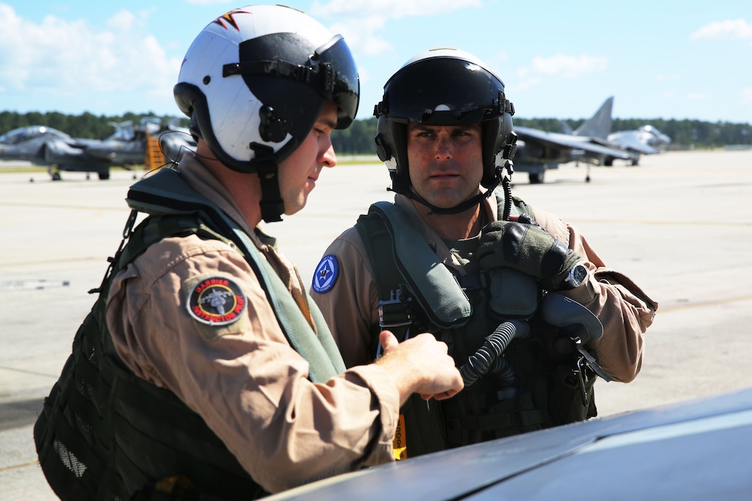 Lt. Col. Wes Spaid, left, assists Capt. Derek Mills during an inspection of an AV-8B Harrier at Marine Corps Air Station Cherry Point, N.C., Aug. 26, 2014. Spaid is the Aviation Combat Element commander with the 24th Marine Expeditionary Unit and visited the air station to get a better understanding of the different aircraft within the ACE. Mills is a Harrier instructor pilot with Marine Attack Training Squadron 203.