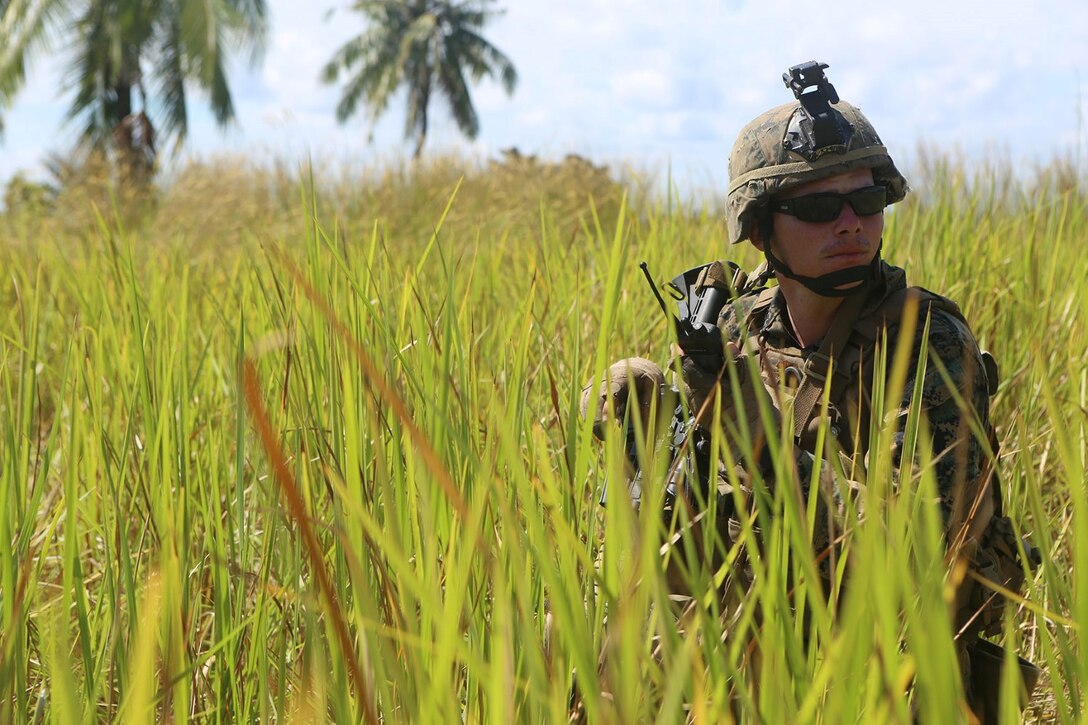 Sgt. Mark Bennettlease, a squad leader with Echo Company, Battalion Landing Team 2nd Battalion, 1st Marines, 11th Marine Expeditionary Unit, receives radio communication during a combined company-sized amphibious assault conducted between Echo Co. Marines and members of the Malaysian Armed Forces as part of Malaysia-United States Amphibious Exercise 2014 Sept. 2. MALUS AMPHEX 14 is a bilateral exercise between the 11th MEU and Malaysian Armed Forces designed to foster and sustain cooperative and international relationships with emphasis on amphibious and humanitarian operations within the context of a stability and security operation. (U.S. Marine Corps photo by Sgt. Melissa Wenger/Released)