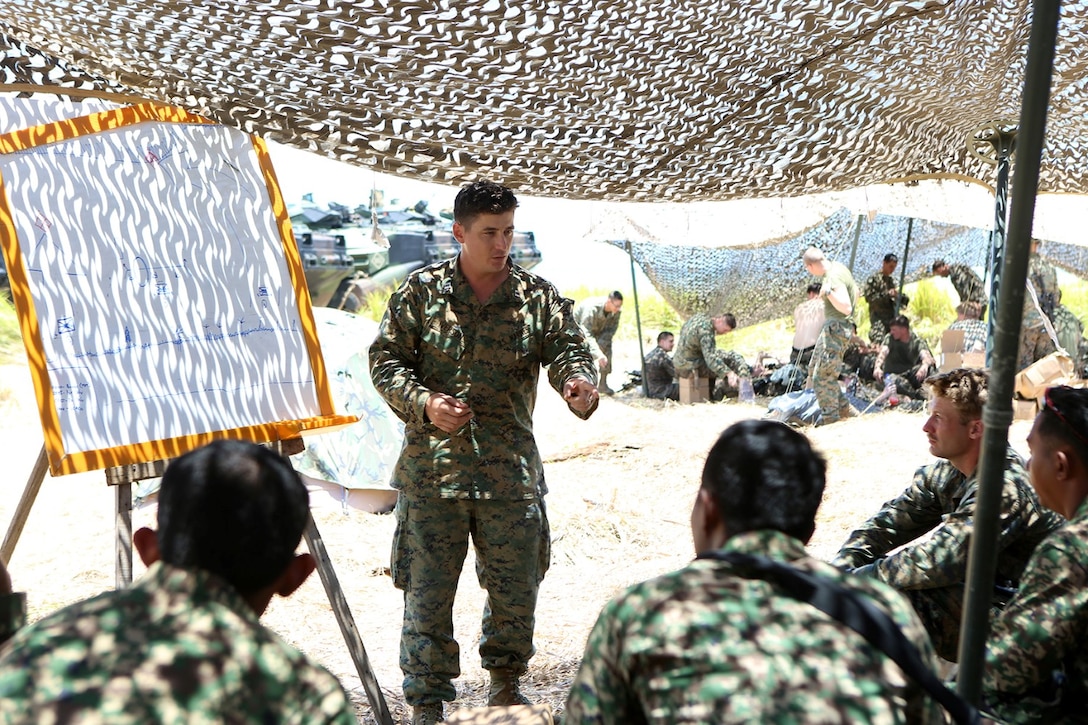 Capt. Larry Iverson Jr., commanding officer of Echo Company, Battalion Landing Team 2nd Battalion, 1st Marines, 11th Marine Expeditionary Unit, discusses a plan for a company-sized assault with other Marine leaders and members of the Malaysian Armed Forces during Malaysia-United States Amphibious Exercise 2014 Aug. 31. MALUS AMPHEX 14 is a bilateral exercise between the 11th MEU and Malaysian Armed Forces that includes operational and tactical level training in planning, command and control, and combat service support using both ground and sea assets. (U.S. Marine Corps photo by Sgt. Melissa Wenger/Released) 
