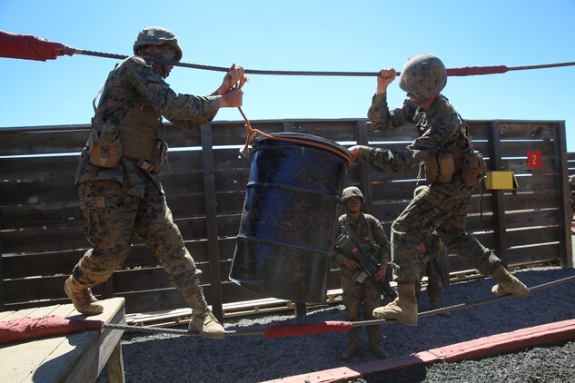 Recruits of Alpha Company, 1st Recruit Training Battalion, work together to get simulated equipment across a bridge during the 12 Stalls event at Marine Corps Base Camp Pendleton,  Calif., Aug. 27.  The Crucible is a 54-hour test of endurance where recruits must conquer more than 30 different obstacles while they experience food and sleep deprivation. During the Crucible, recruits utilize small unit leadership skills they’ve acquired throughout training at events such as 12 Stalls.