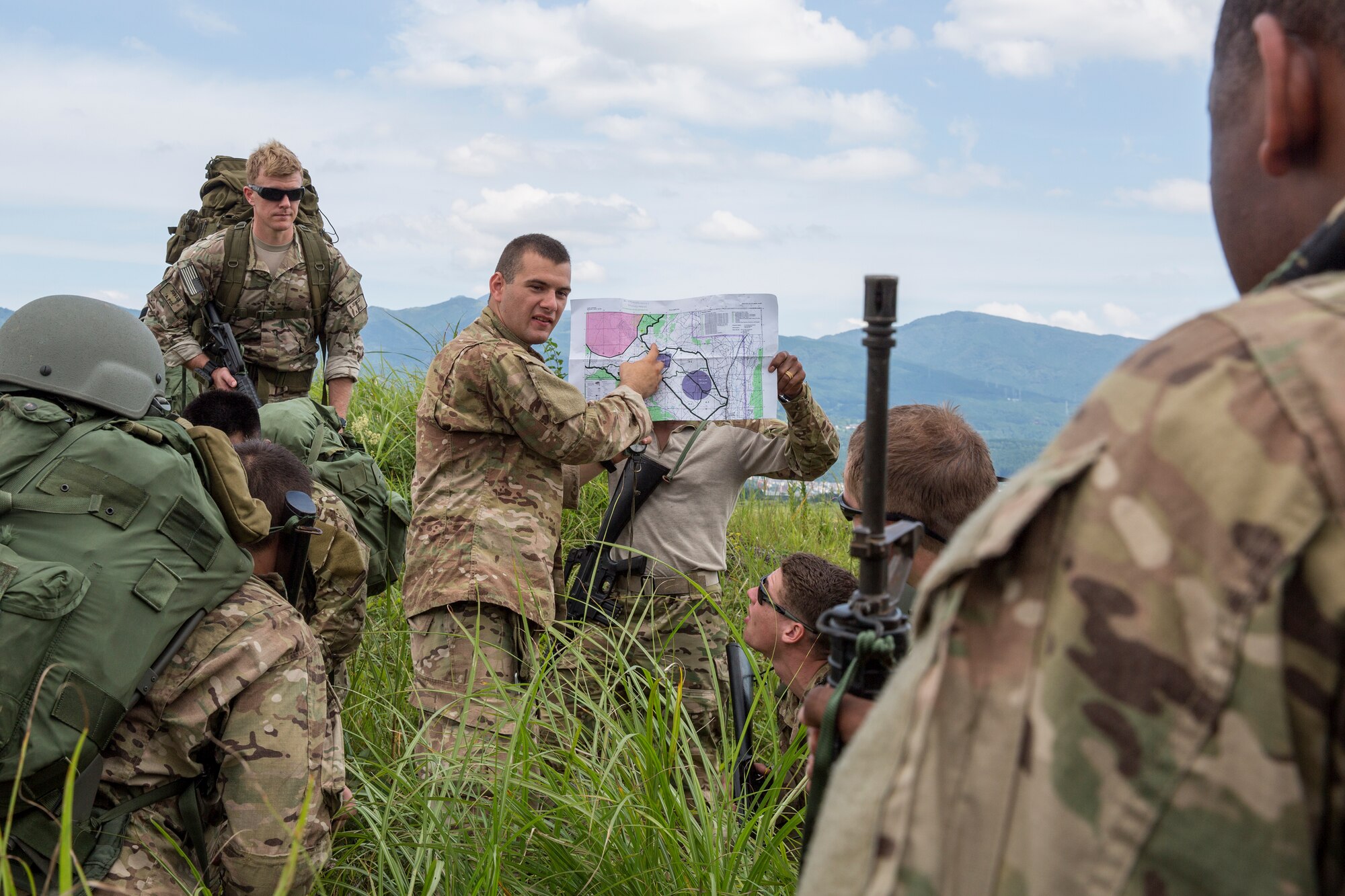 A U.S. Soldier gives a brief his team members after completing jump training at Combined Arms Training Center Camp Fuji, Japan, Sept. 3, 2014. The Soldiers are with the 1st Battalion, 1st Special Forces Group (Airborne). (U.S. Air Force photo by Osakabe Yasuo/Released)