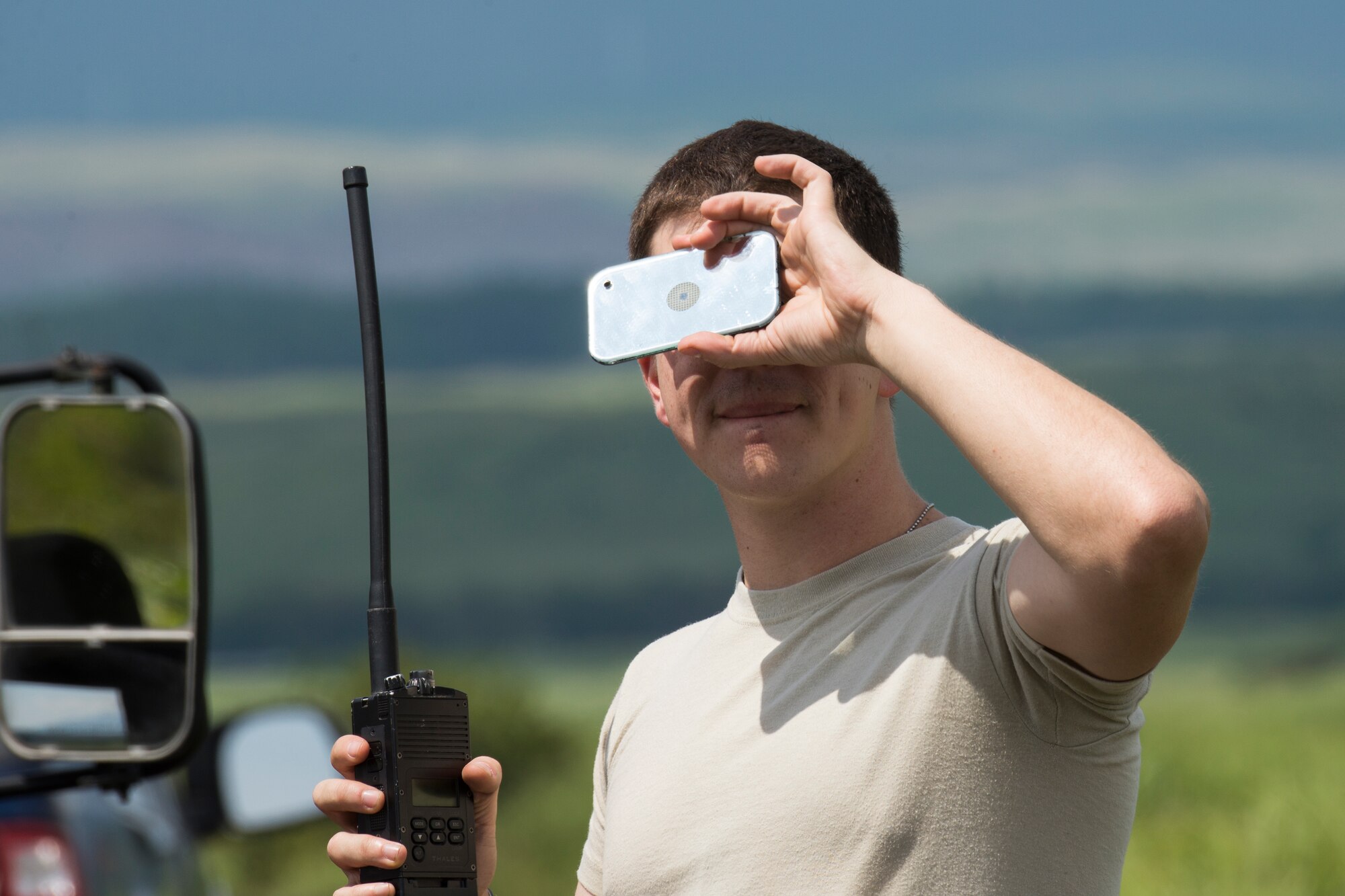 1st Lt. Jonathan Vanpinxteren, 36th Airlift Squadron drop zone safety liaison, uses a signal mirror to coordinate a drop zone with C-130 Hercules pilot and navigator at Combined Arms Training Center Camp Fuji, Japan, Sept. 3, 2014. The drop zone can be hard to find from a distance, but the mirror creates a flash that can be seen from miles away. (U.S. Air Force photo by Osakabe Yasuo/Released)