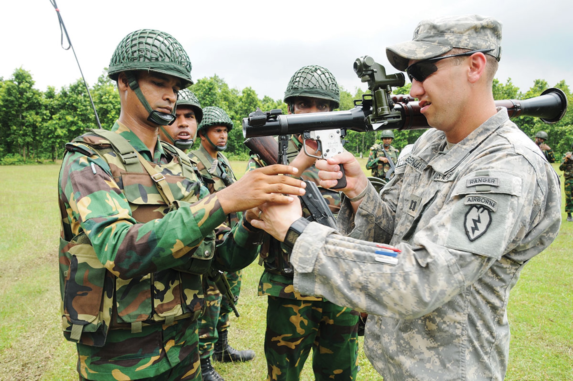 Capt. Bradley Benjamin (right), commander of Delaware Company, 1st Battalion (Airborne), 501st Infantry Regiment, 4th Infantry Brigade Combat Team (Airborne), 25th Infantry Division, peers through the sites of a Bangladesh Army 40 mm rocket launcher as Bangladesh soldiers with the 46th Independent Infantry Brigade instruct him on its components Aug. 26, 2014, at the Rajendrapur Catonement Training Area, near Dhaka, Bangladesh. Benjamin and the U.S. Army were in Bangladesh for Aurora Monsoon, a bilateral exchange and training exercise focused on building relationships and enhancing abilities in operating in a jungle environment and unfamiliar terrain. (U.S. Army photo by Sgt. 1st Class Jeffrey Smith/Released)