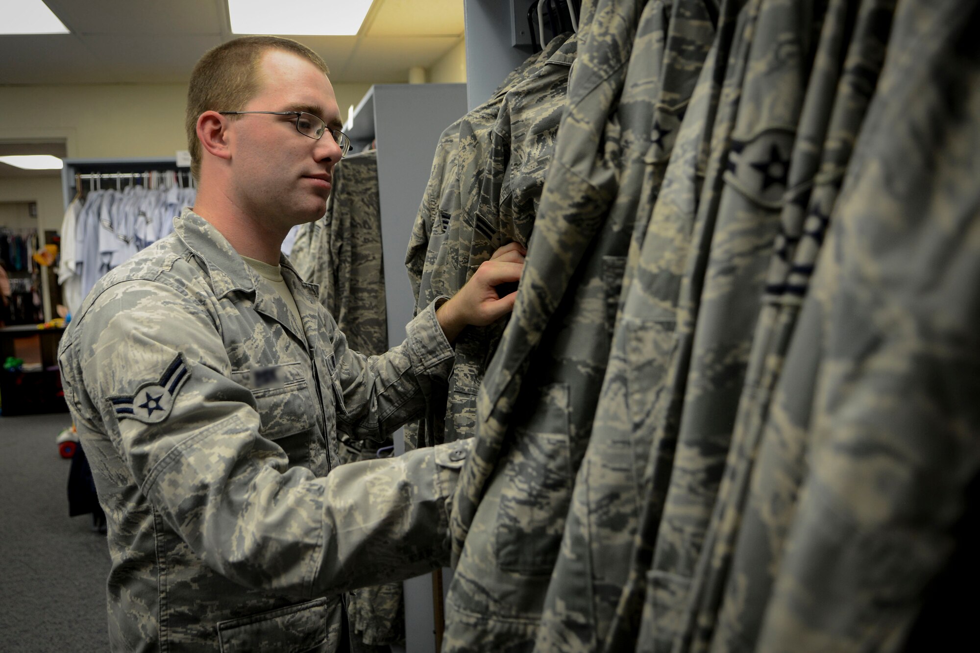 Airman 1st Class Colton, 9th Intelligence Squadron, looks for uniforms at the Airman’s Attic on Beale Air Force Base, Calif., July 15, 2014. The Airman’s Attic is a place where E-7s and below, as well as 0-3s and below, can get free clothing and household items. During the fourth Saturday of every month the Airman’s Attic is open to all ranks. (U.S. Air Force photo by Senior Airman Shana Wojcik/Released)