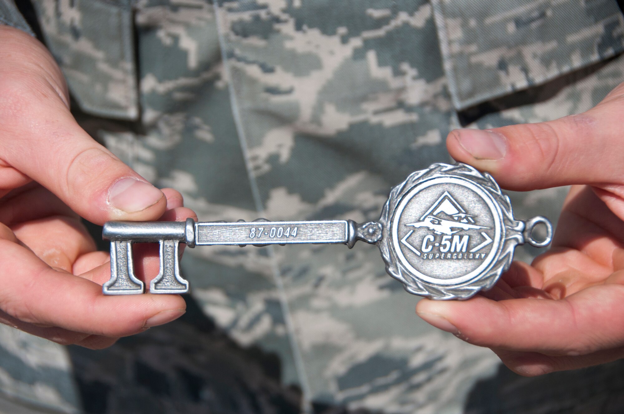 Airman 1st Class Joey Petter, 60th Aircraft Maintenance Squadron jet engine specialist, displays the key to the newly refurbished C-5M Super Galaxy Aug. 26 on the Travis flighline. (U.S. Air Force photo by Tech. Sgt. Patrick Harrower)