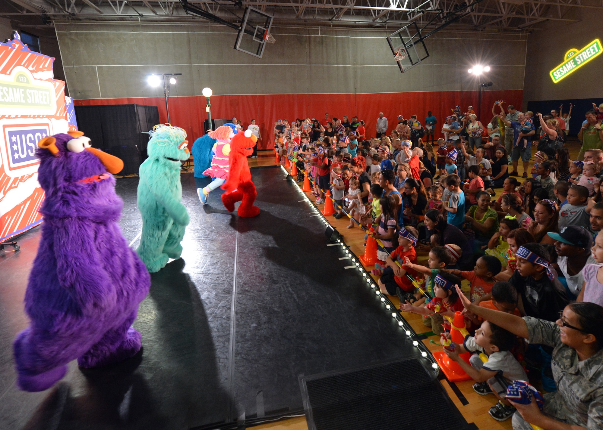 Excited children stand near the stage during The Sesame Street USO Experience for Military Families. The show helped children understand that moving due to a parent’s permanent-change-of-station may be sad and difficult but keeping in touch with friends is easy. (U.S. Air Force photo/Senior Airman Devante Williams)
