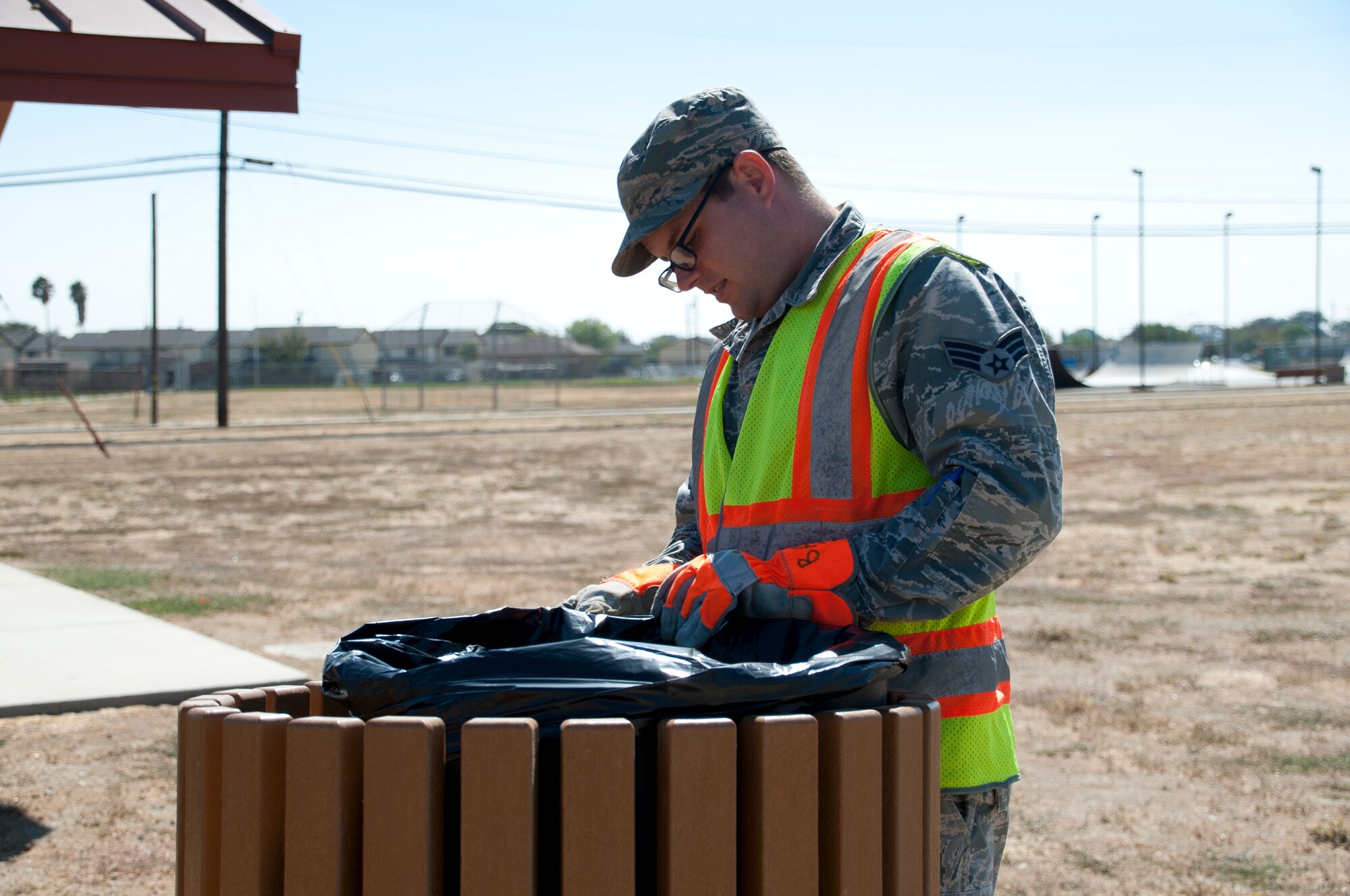 Senior Airman Zachary Burns, 60th Operations Support Squadron air traffic control and Base Appearance Team apprentice, collects trash September 2 at Travis Air Force Base. Travisville park, the skatepark and the duck pond are all cleaned by the Base Appearance Team. (U.S. Air Force photo by Airman 1st Class Amber Carter)