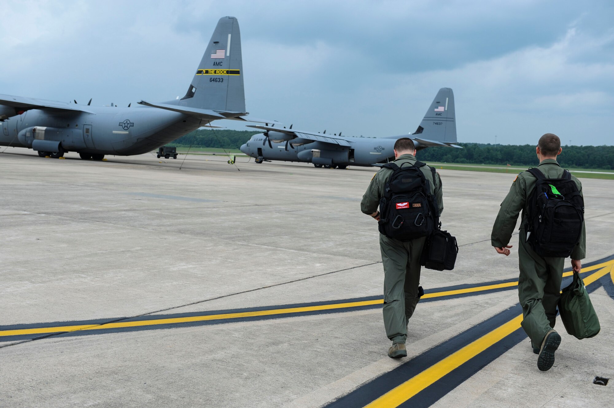 Capt. Steve Kadrich and Capt. Brian Boardman, 41st Airlift Squadron C-130J pilots, step toward their assigned Herk Aug. 7, 2014, at Little Rock Air Force Base, Ark. These Airmen were a part of a two-ship C-130 formation that dropped two simulated container delivery systems. (U.S. Air Force photo by Airman 1st Class Cliffton Dolezal)