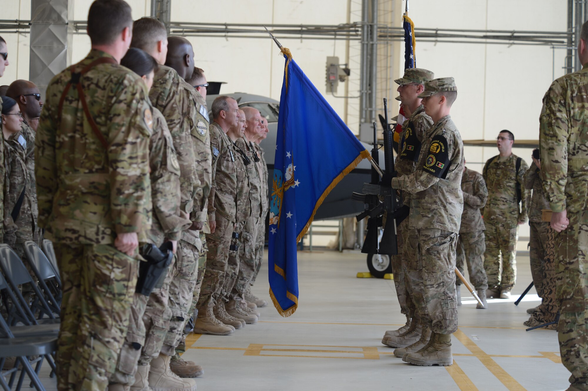 U.S. Service members and civilians stand at attention as the Kandahar Airfield Honor Guard present the colors during the beginning of 361st Expeditionary Reconnaissance Squadron deactivation ceremony Sept. 1, 2014 at Kandahar Airfield, Afghanistan.  The 361 ERS was responsible for intelligence, surveillance and reconnaissance throughout Regional Command-South. (U.S. Air Force photo by Master Sgt. Cohen A. Young/Released)