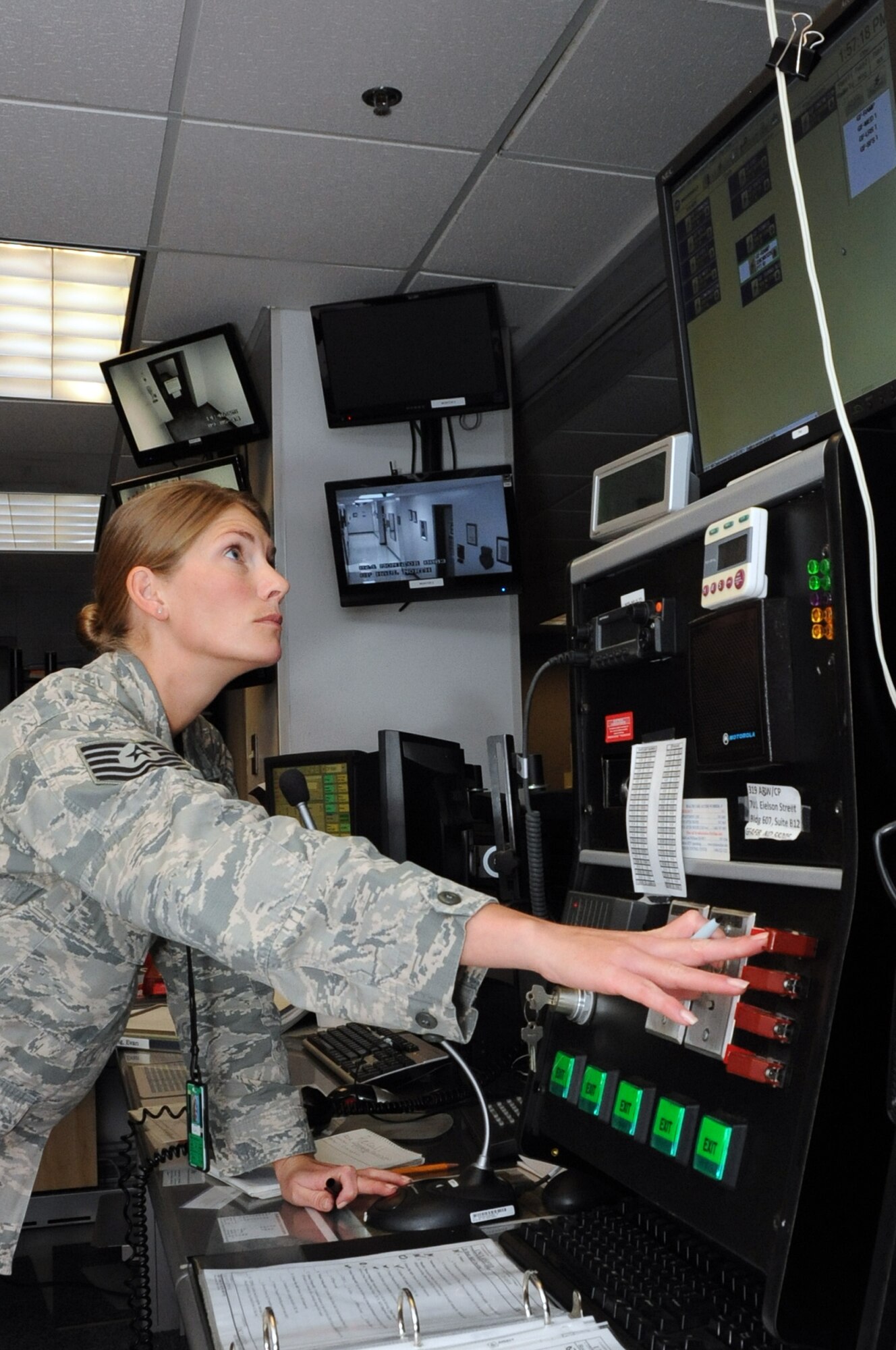 Tech. Sgt. Krystal French, 319th Air Base Wing NCO in charge of command post operations, speaks to the base populace over the Land Mass Radio trunk system in the command post on Grand Forks Air Force Base, N.D., September 4, 2014. French was selected as the base's Warrior of the Week for the first week of September 2014. (U.S. Air Force photo/Staff Sgt. David Dobrydney)